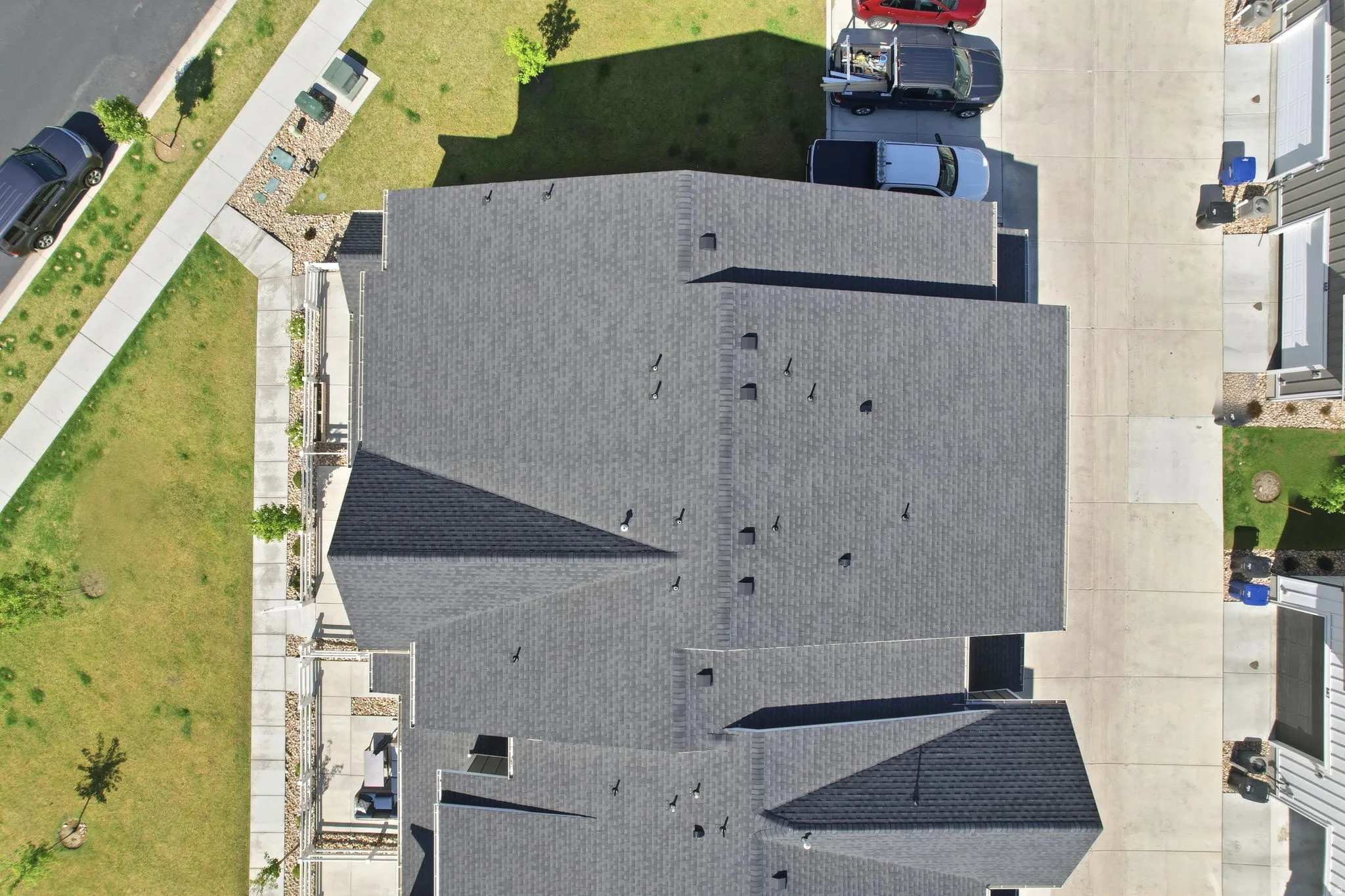 New construction featuring a multi-gabled roofline with dark shingle roofing, and a concrete driveway leading to a two-car garage