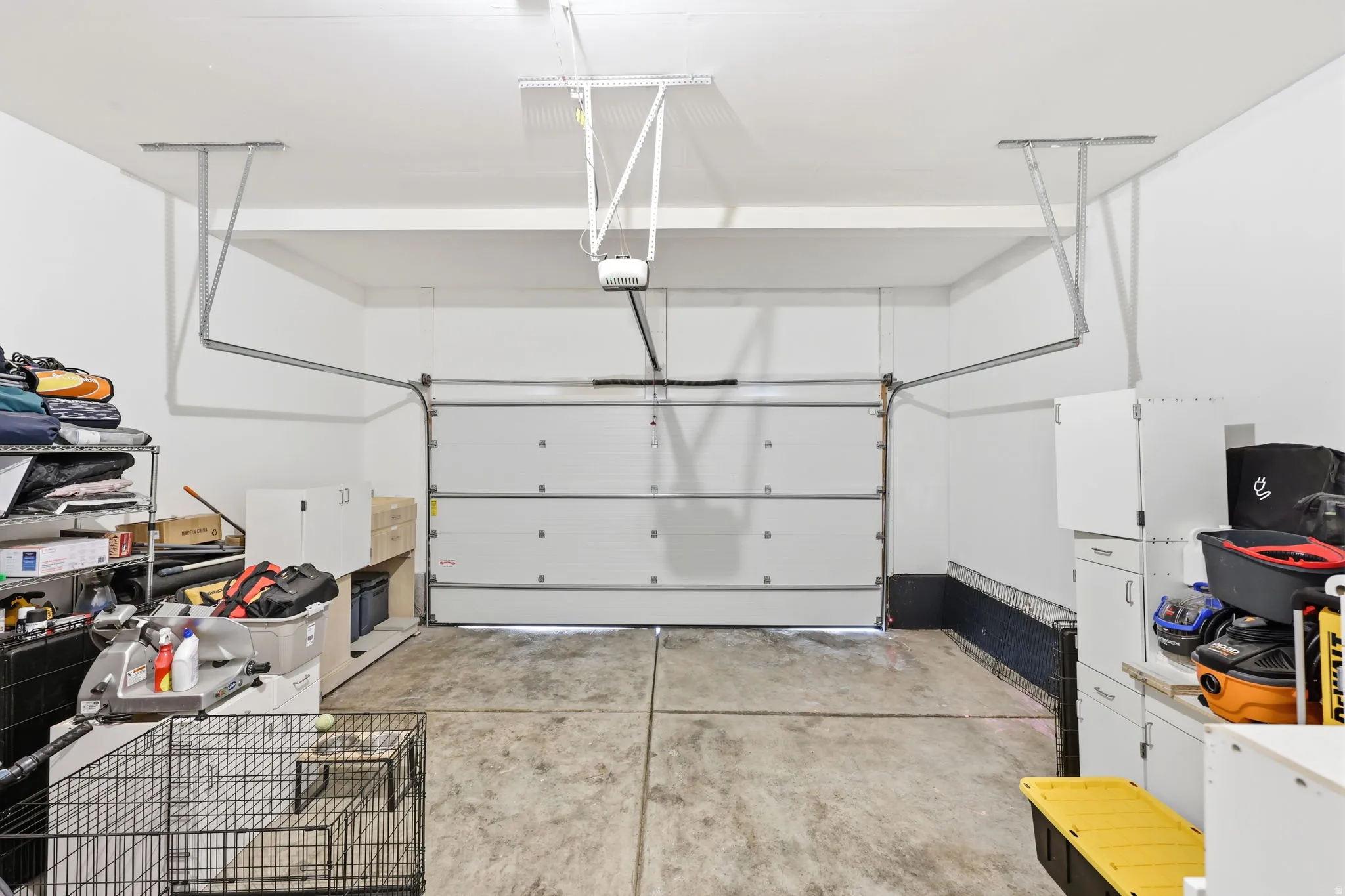 Spacious garage featuring a concrete floor, white walls, and a sectional garage door