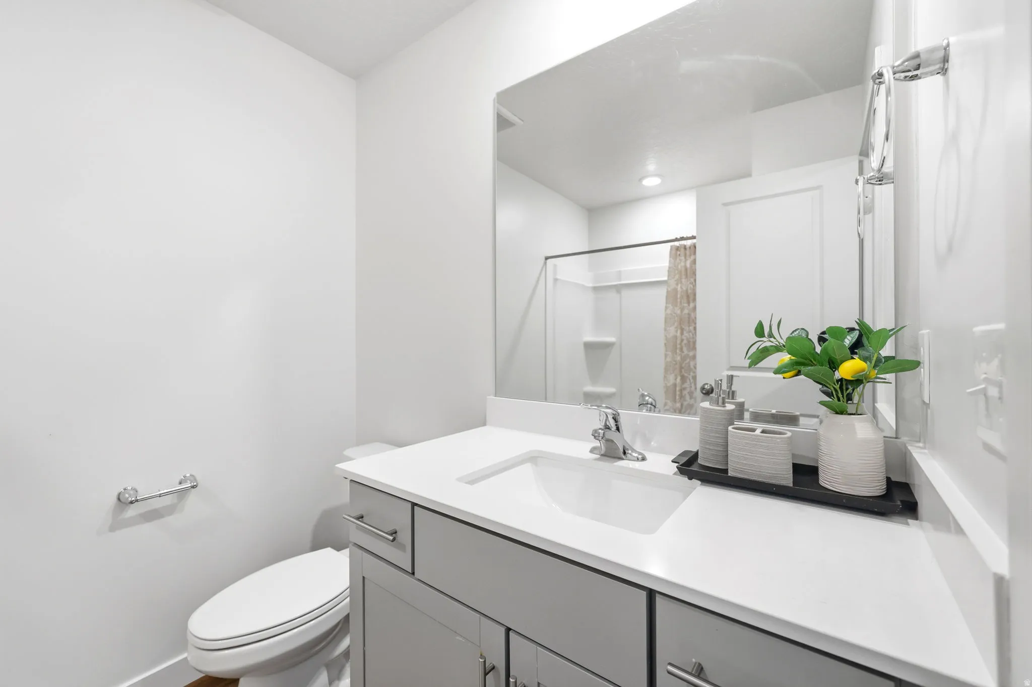 Modern bathroom featuring a single-sink vanity with light gray cabinetry, white countertop, and an integrated rectangular sink