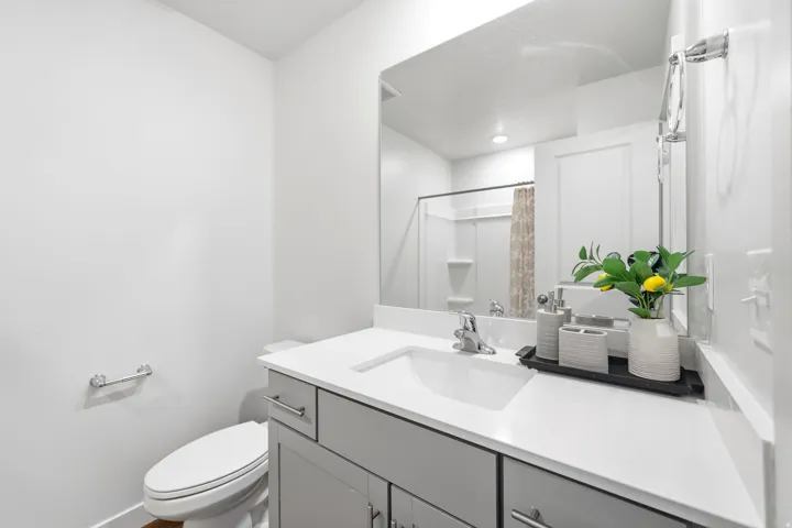 Modern bathroom featuring a single-sink vanity with light gray cabinetry, white countertop, and an integrated rectangular sink