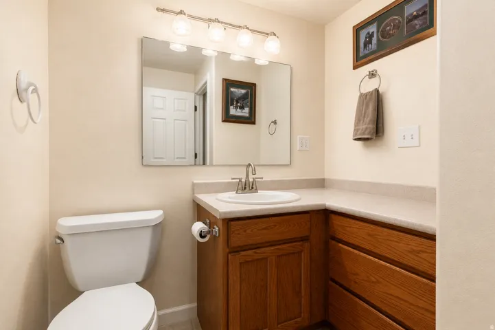 Bathroom featuring a vanity with a white oval sink, chrome faucet, and a light-toned countertop