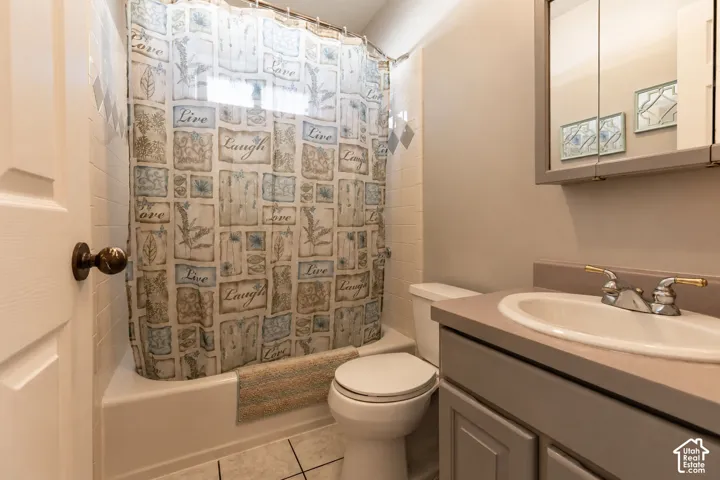 Bathroom featuring a white porcelain tub, toilet, and a vanity with an integrated sink