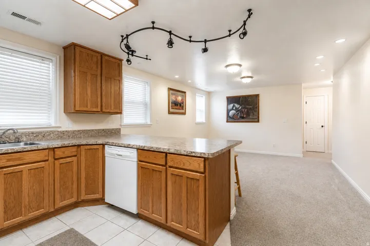 Second Kitchen featuring wood cabinetry, stone-look countertops, and a stainless steel sink