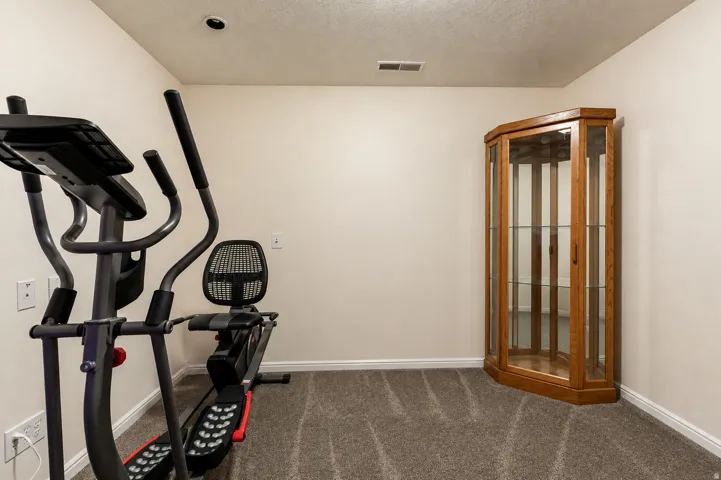 Carpeted room with recessed lighting and a corner display cabinet