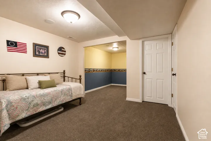Carpeted room featuring a white paneled door, recessed lighting, and a neutral wall color