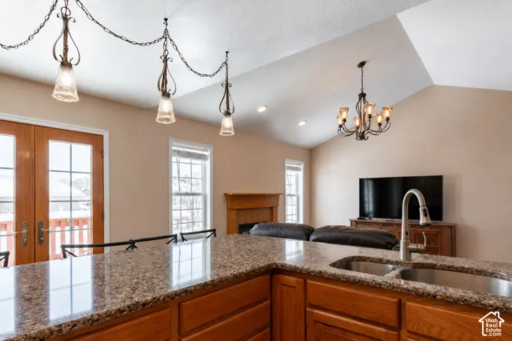 Kitchen island featuring a double basin stainless steel sink with gooseneck faucet and granite-style countertop