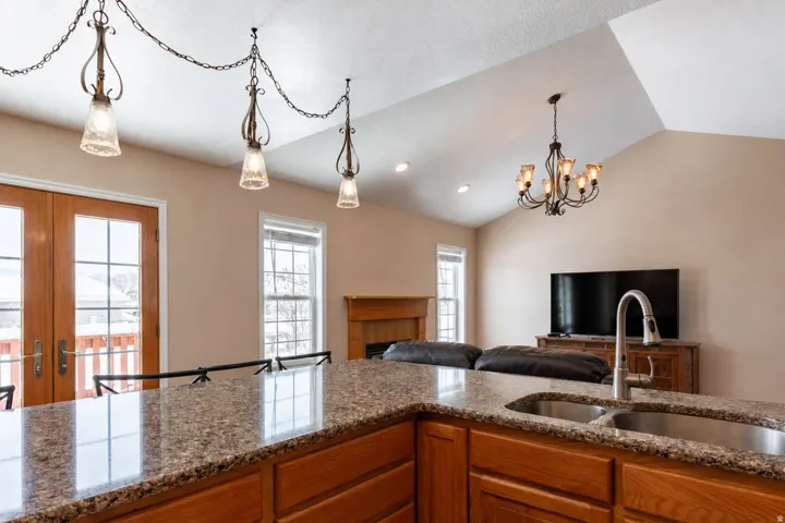 Kitchen island featuring a double basin stainless steel sink with gooseneck faucet and granite-style countertop