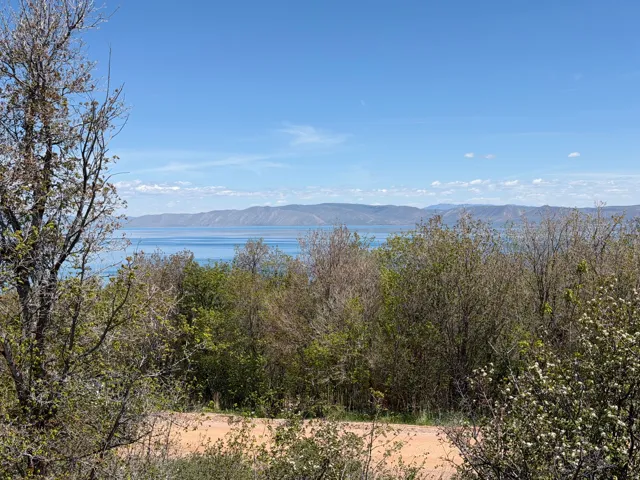 Expansive water body framed by distant mountain ranges under a clear sky
