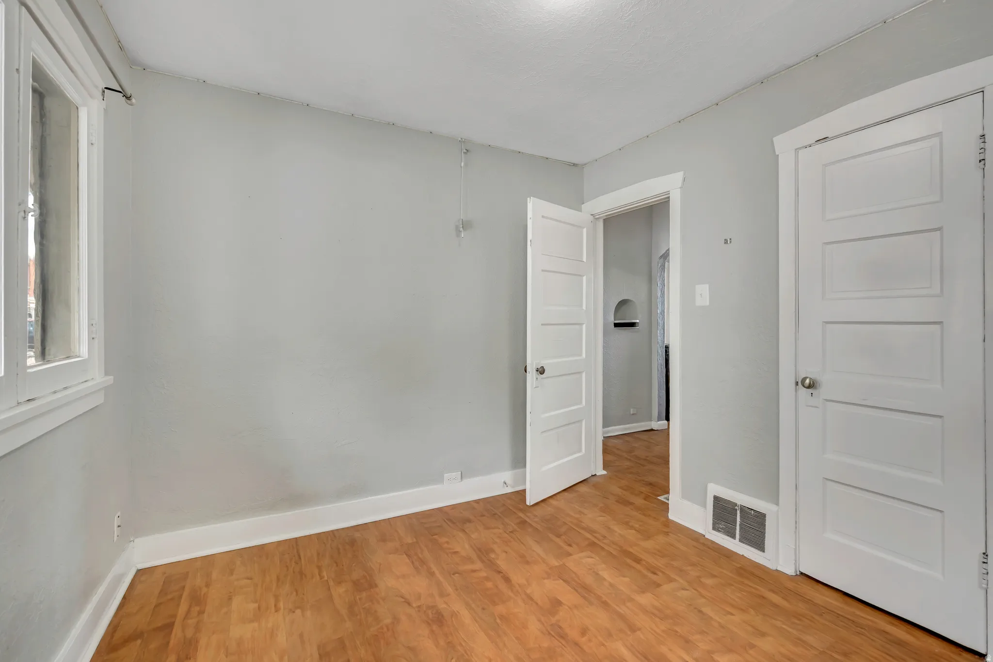 Interior space featuring wood-finish flooring, white baseboards, and light gray walls