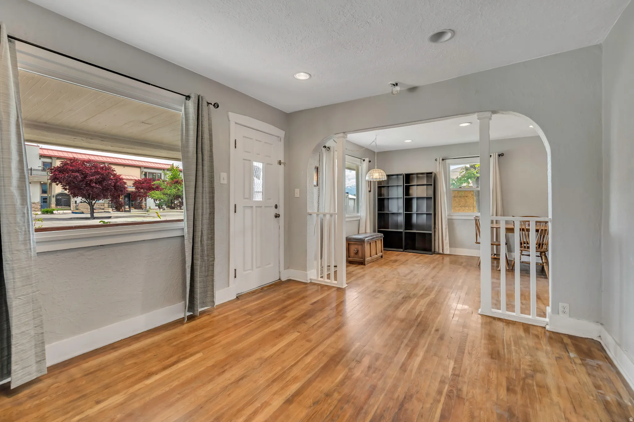 Bright living area featuring wood-finish flooring, light gray wall paint, and recessed lighting