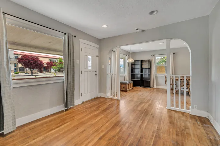 Bright living area featuring wood-finish flooring, light gray wall paint, and recessed lighting