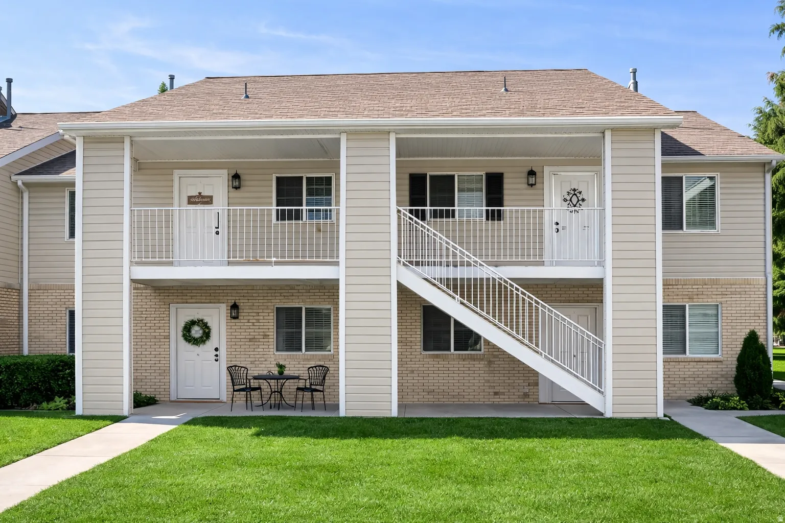 Two-story building featuring tan siding and light brick accents