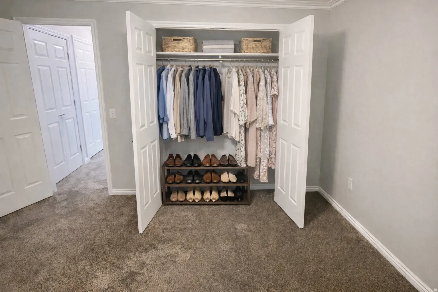 Spacious closet featuring bi-fold doors, white trim, and ample storage with upper shelving and hanging rods