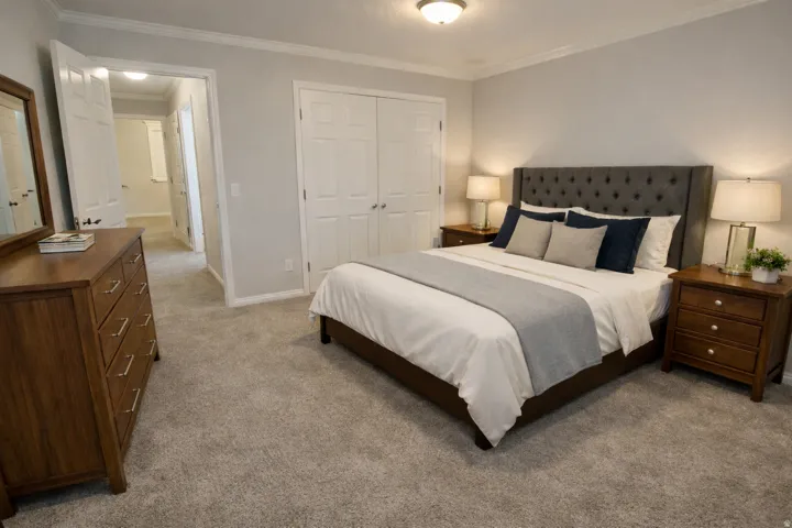 Carpeted bedroom featuring a double-door closet, crown molding, and a flush mount ceiling light