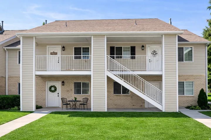 Two-story building featuring tan siding and light brick accents