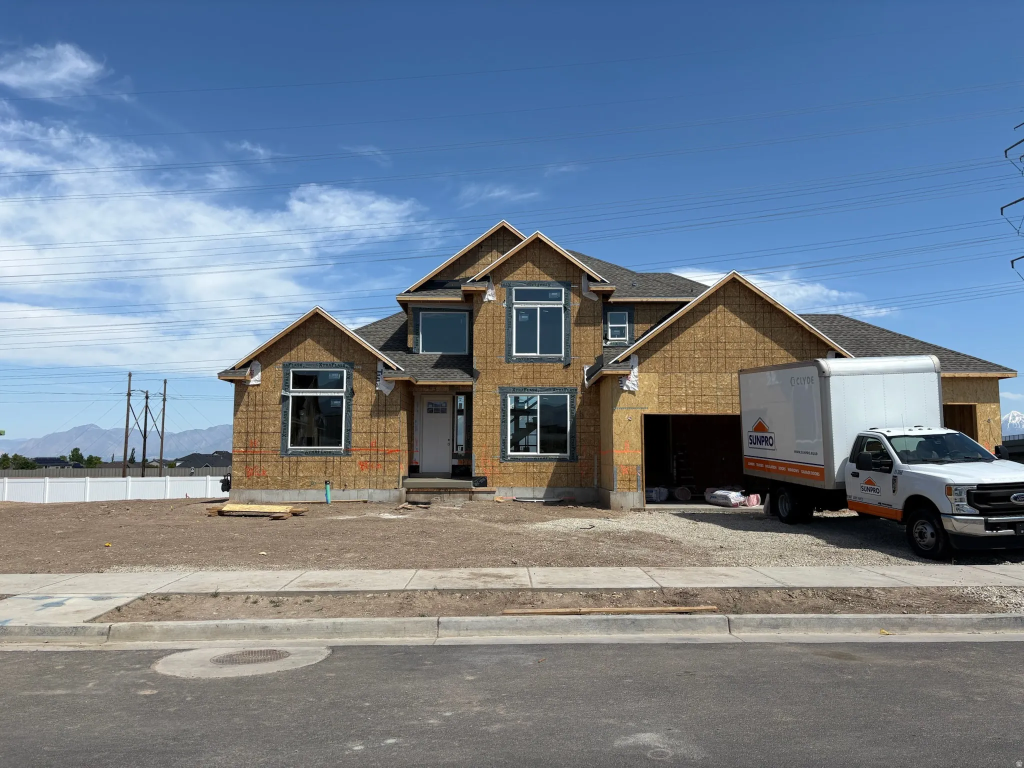 New construction residence featuring a multi-gable roofline, attached two-car garage, and a concrete driveway apron