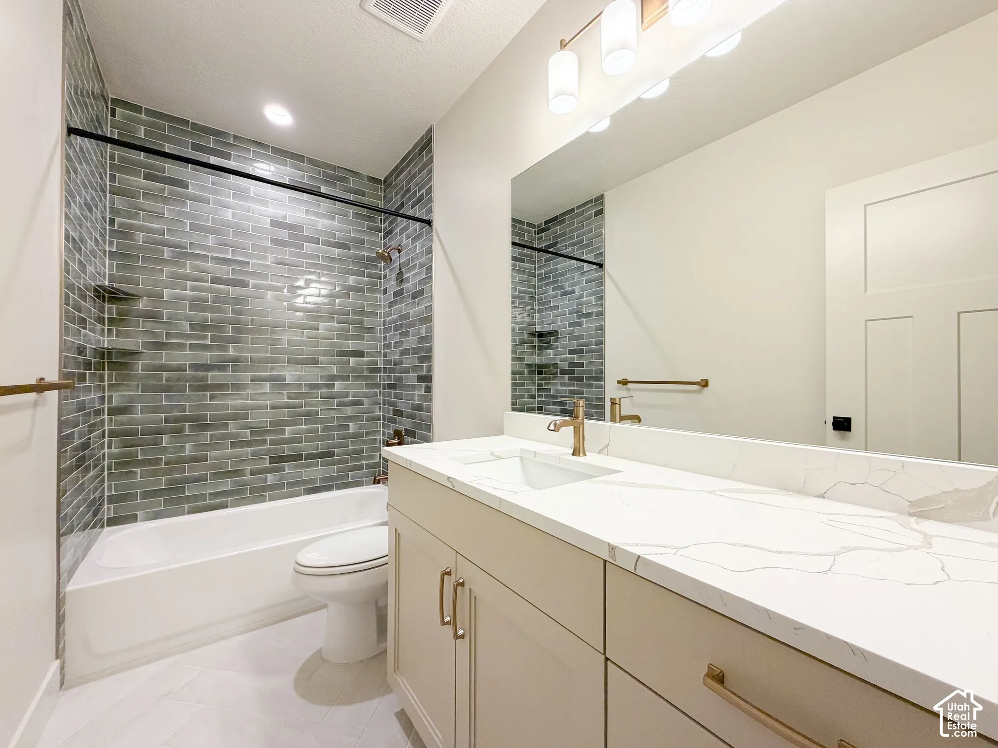 Tub and shower combination featuring a grey subway tile surround with integrated shelving