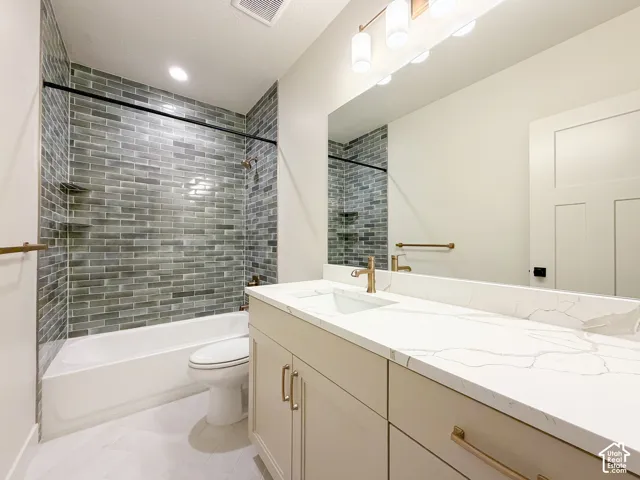 Tub and shower combination featuring a grey subway tile surround with integrated shelving