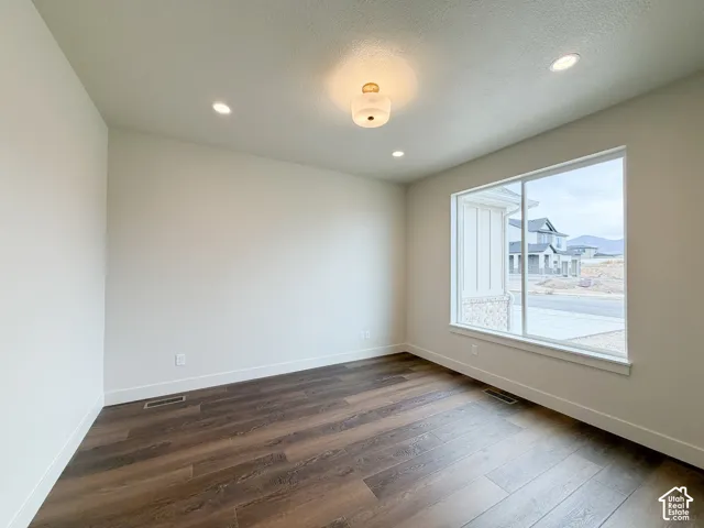 Expansive window providing natural illumination, complemented by wood-finish flooring, recessed lighting, and a central ceiling fixture.Good size office with doors .