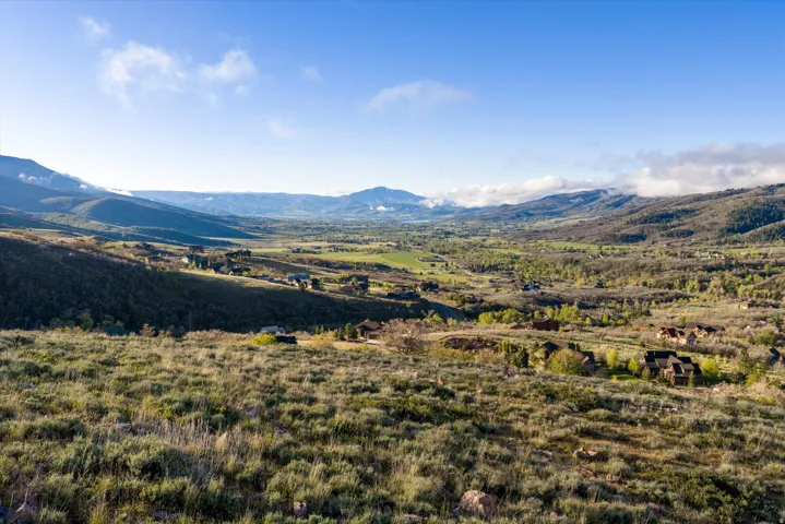 Expansive mountain landscape featuring a valley with scattered residential properties