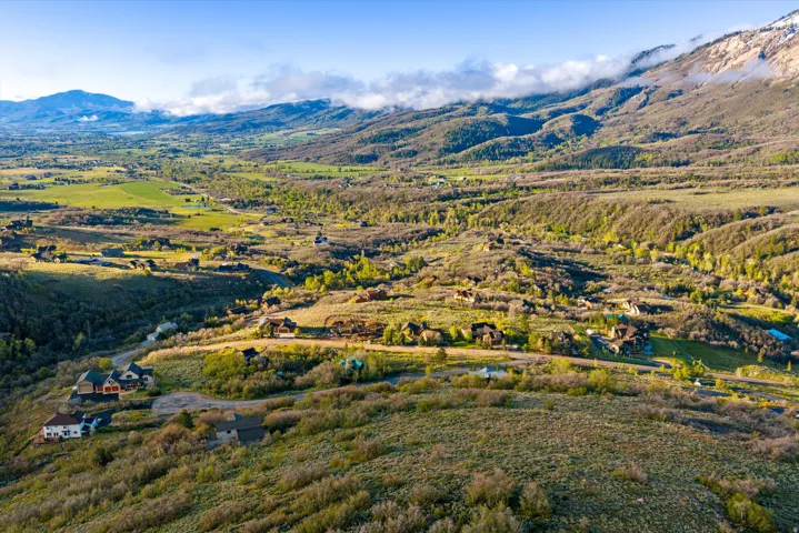 Expansive mountain landscape featuring varied terrain and scattered residential properties
