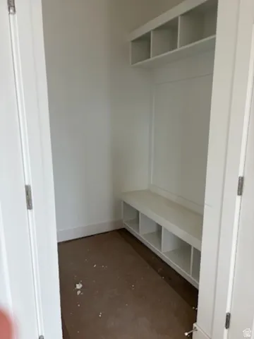 Built-in entry system featuring a seating bench with integrated cubbies and overhead shelving, all finished in white