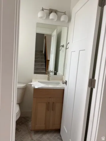 Bathroom vanity with a wood-finish cabinet, white countertop, and brushed nickel faucet