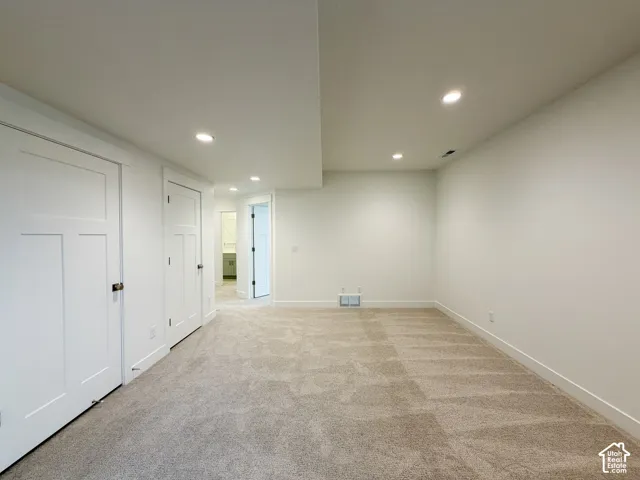 Plush carpeting, recessed lighting, white interior doors with dark hardware, and clean white walls