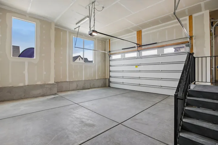 Concrete flooring with expansion joints, dual windows, and an automatic garage door opener