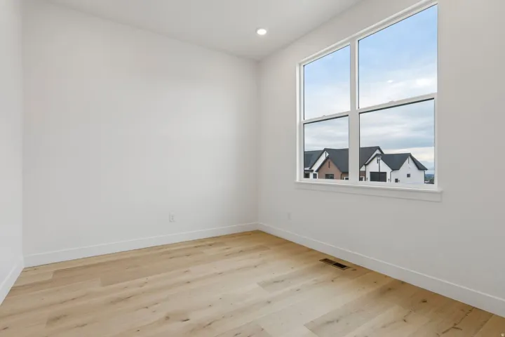 Spacious room with wood-finish flooring and a large window