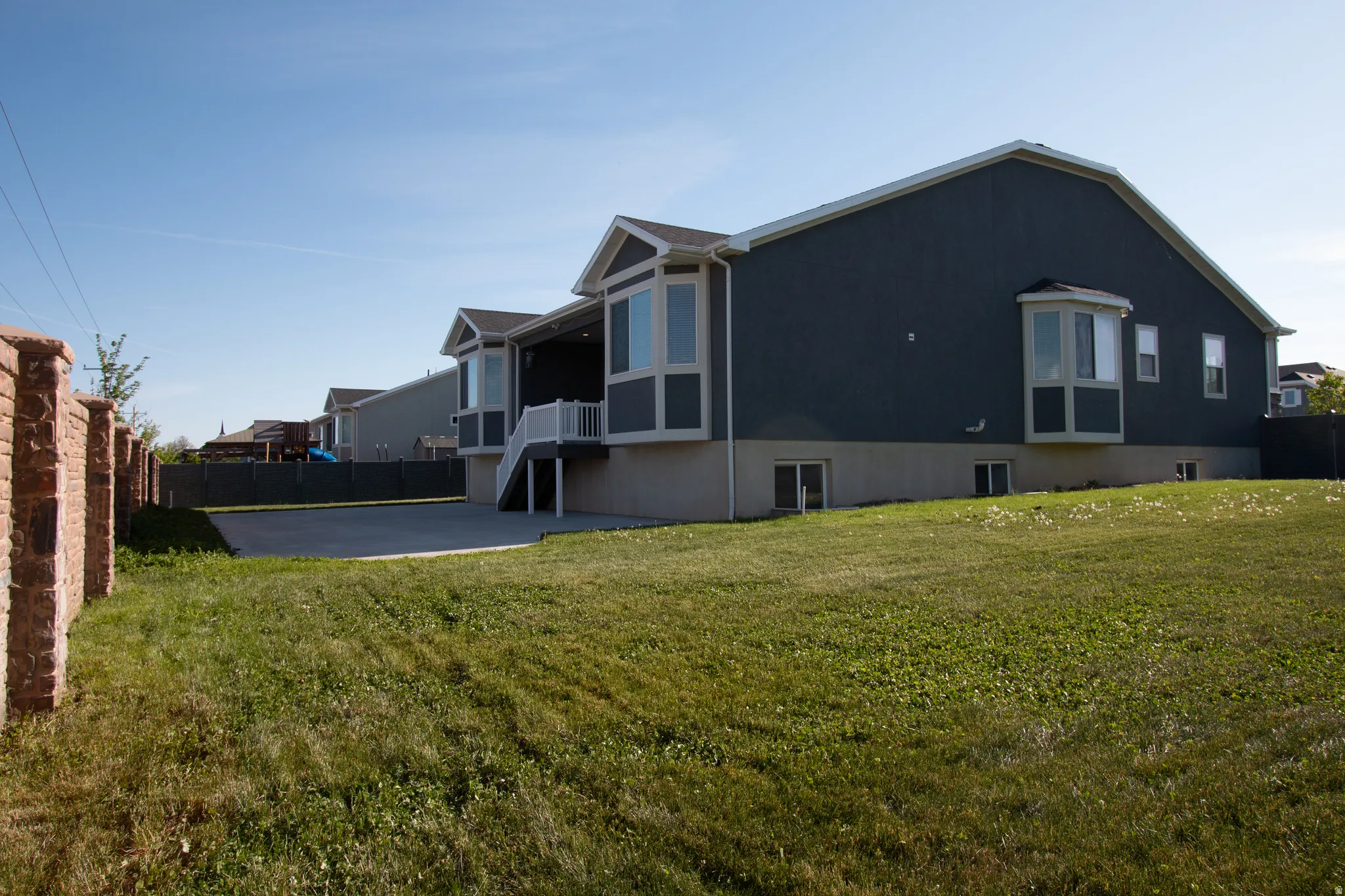 Contemporary residence with dark gray siding and white trim