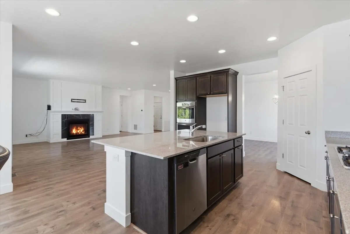 Central kitchen island featuring a double-basin stainless steel sink, integrated dishwasher, and light-toned countertop