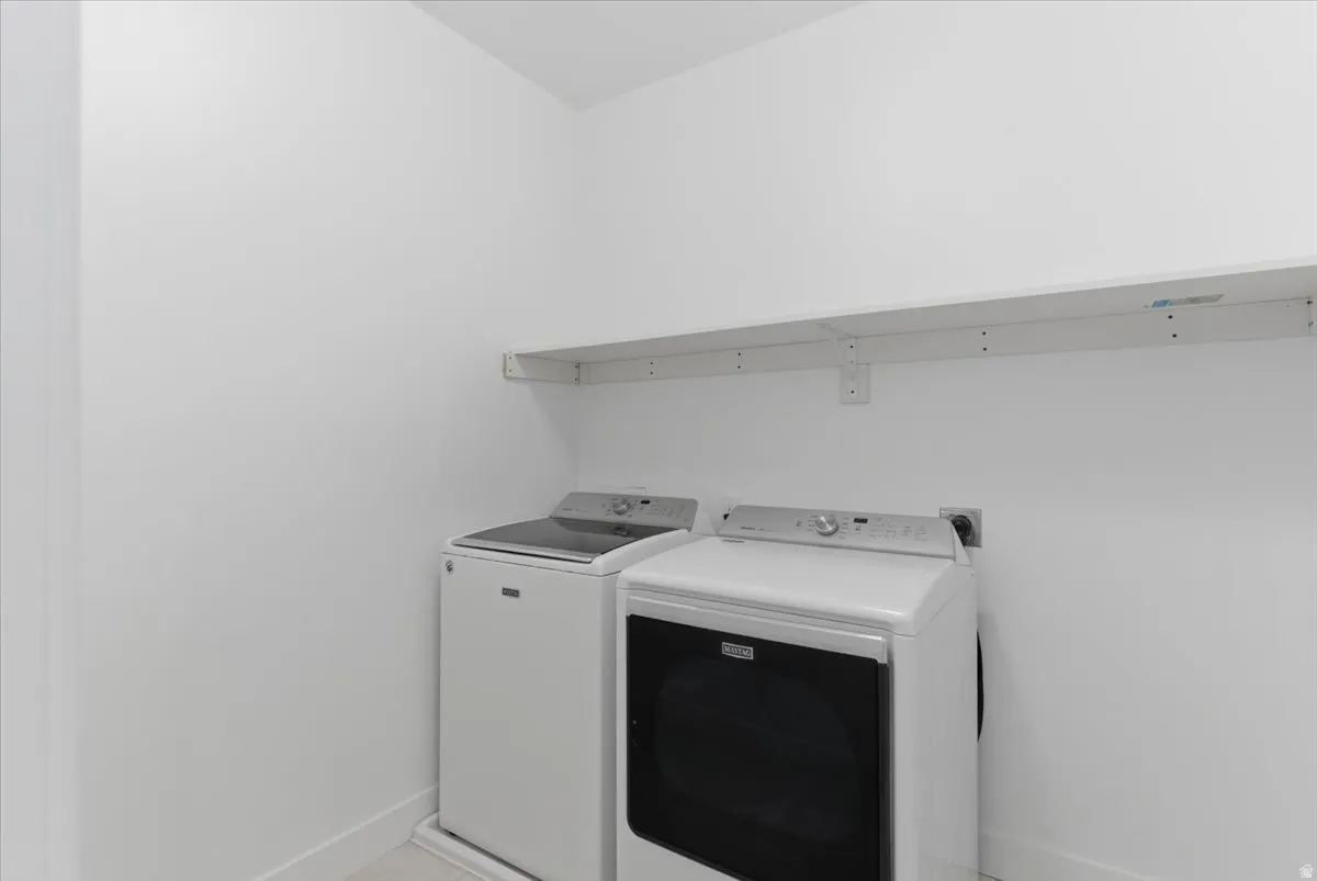 Dedicated laundry area with a white shelving unit for storage