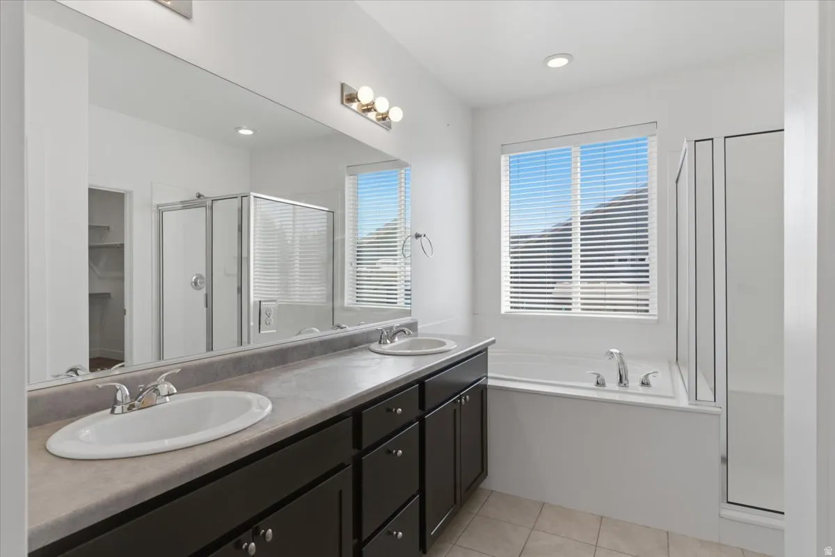Double vanity with dual undermount sinks, extended countertop, and dark wood cabinetry