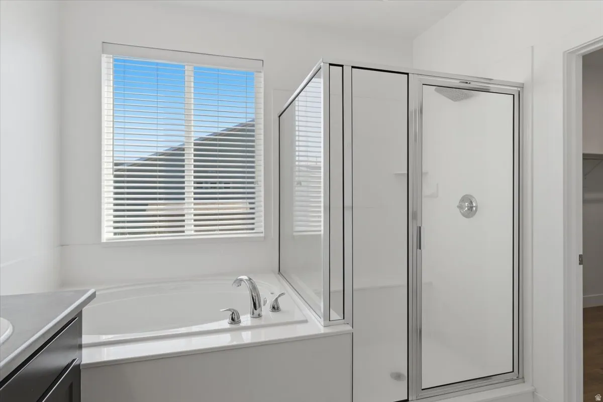 Corner soaking tub with polished chrome fixtures and a frosted glass shower enclosure