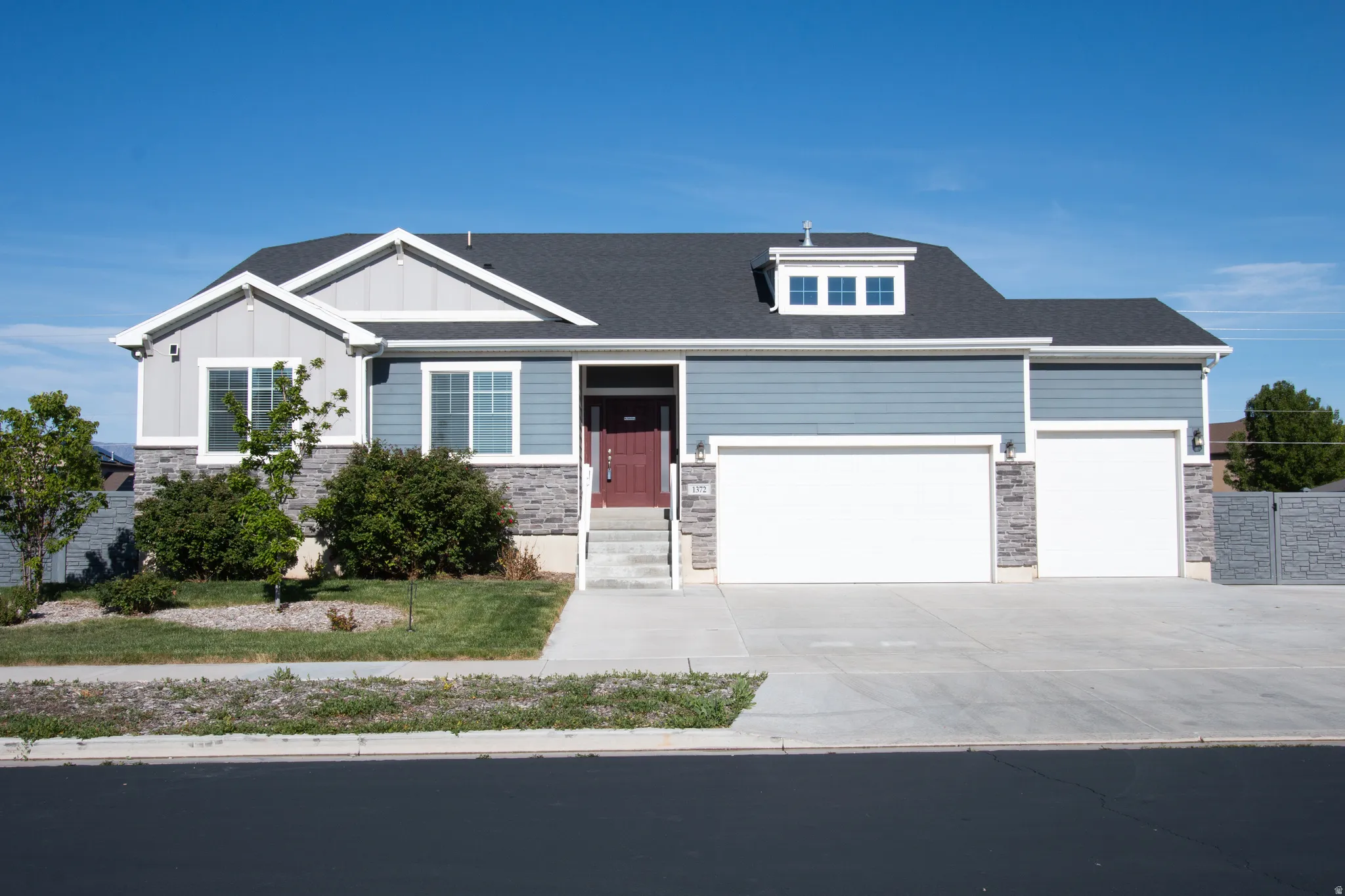 Contemporary residence featuring a blue and gray siding facade with stone accents