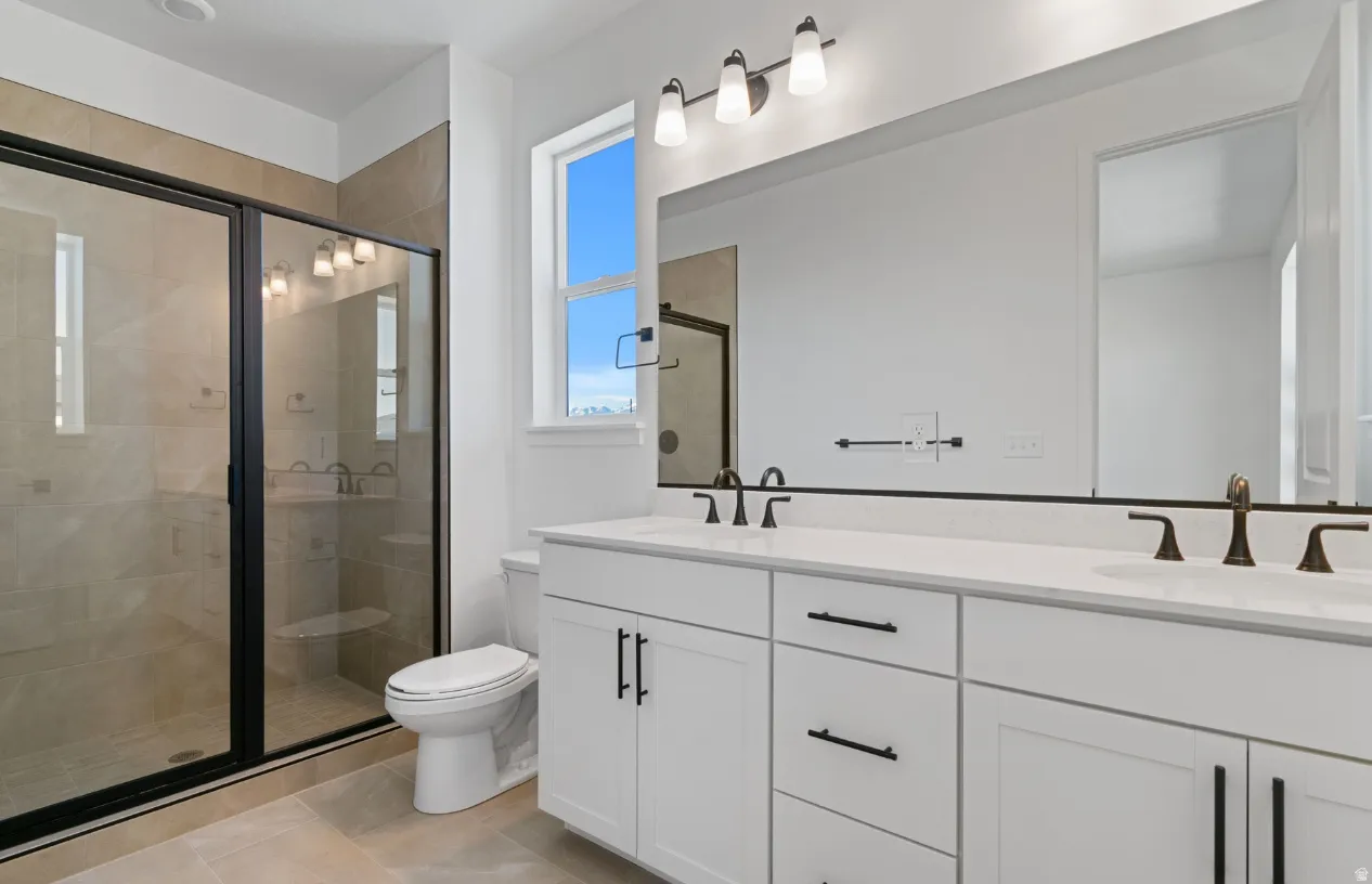 Bathroom featuring a dual vanity with white cabinetry, integrated sinks, and bronze-finish fixtures