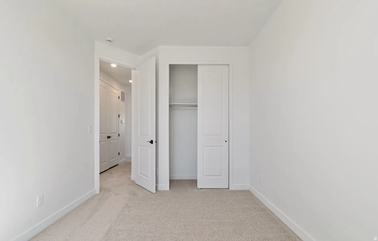 Neutral-toned carpeting complements the white walls and trim throughout this room