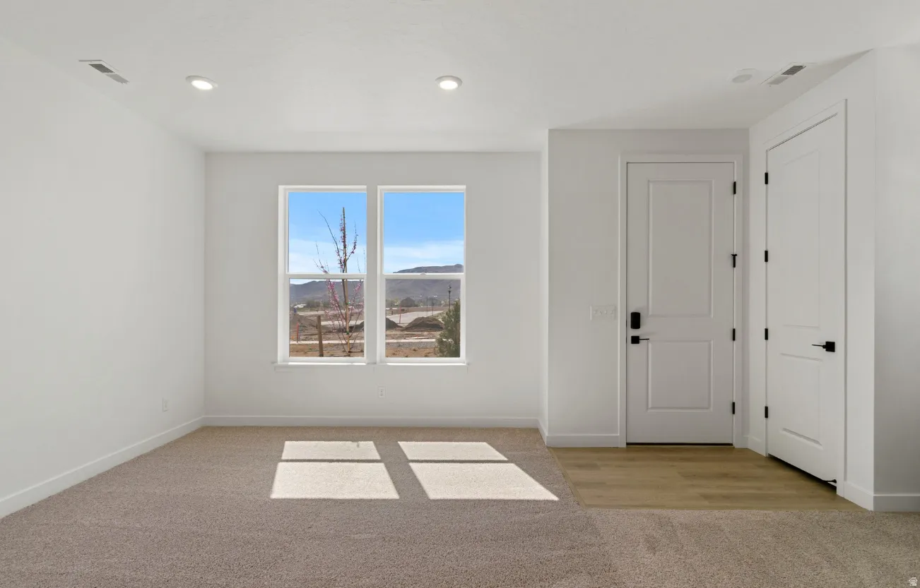 Bright room featuring dual windows, recessed lighting, and a neutral color palette