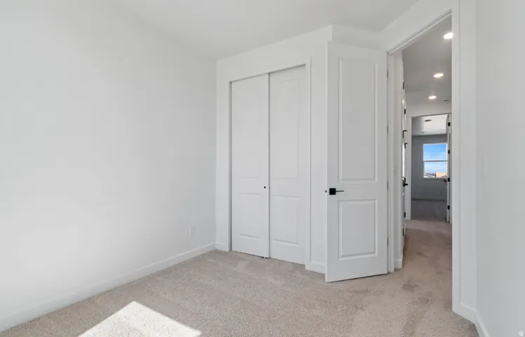 Neutral-toned carpet flooring and white walls define this interior space