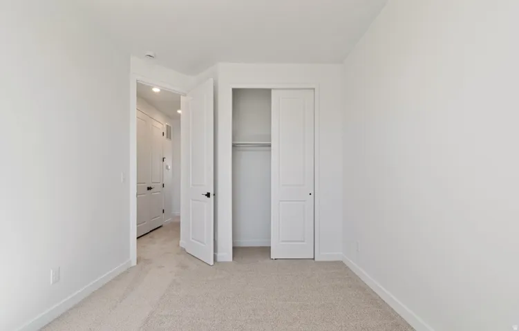 Neutral-toned carpeting complements the white walls and trim throughout this room