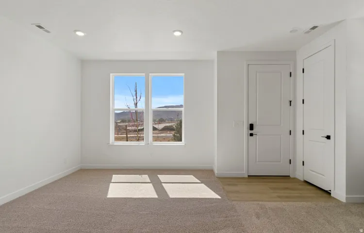 Bright room featuring dual windows, recessed lighting, and a neutral color palette