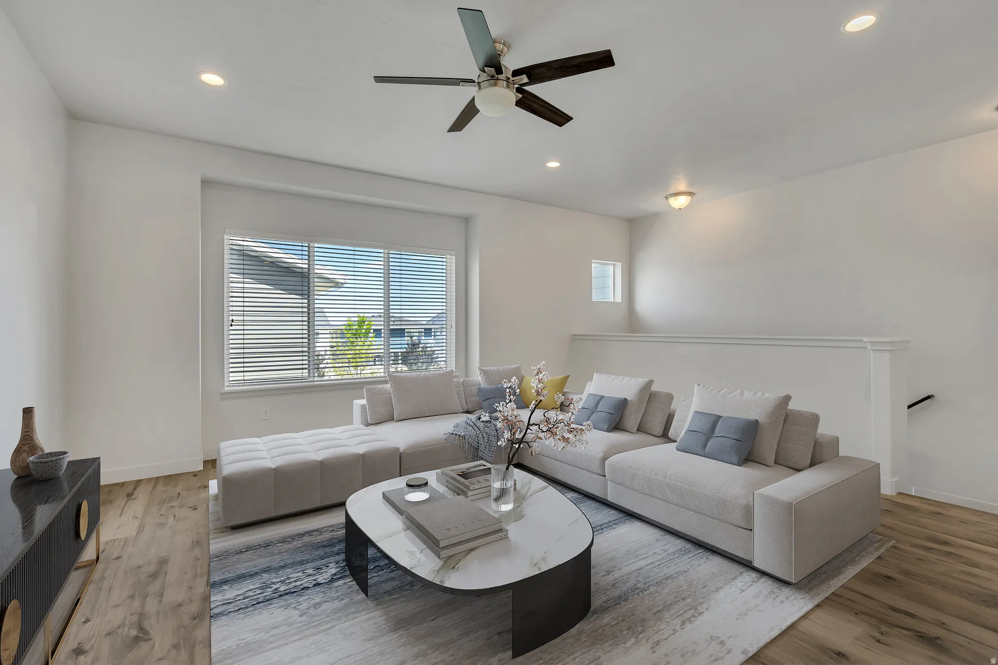 Living area featuring wood-finish flooring, recessed lighting, and a multi-pane window with horizontal blinds