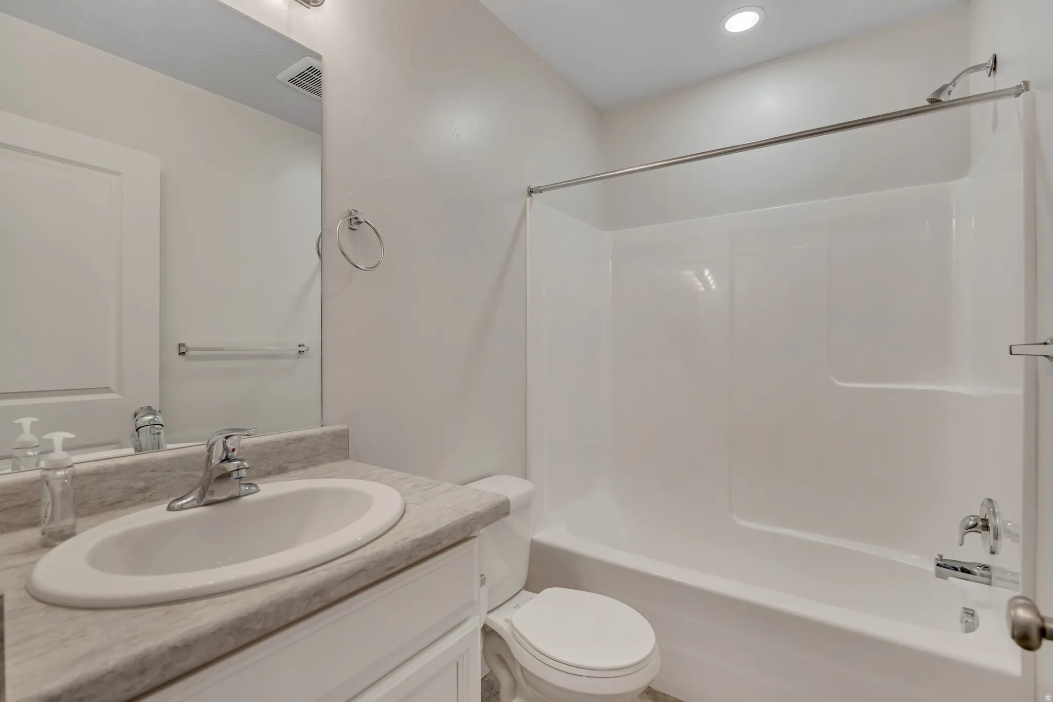 Bathroom featuring a white vanity with an undermount sink, a light-toned countertop, and a chrome faucet