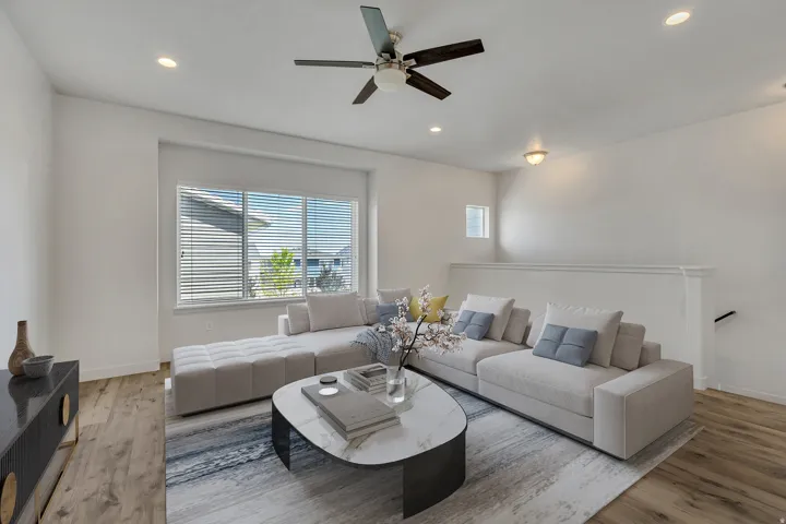 Living area featuring wood-finish flooring, recessed lighting, and a multi-pane window with horizontal blinds