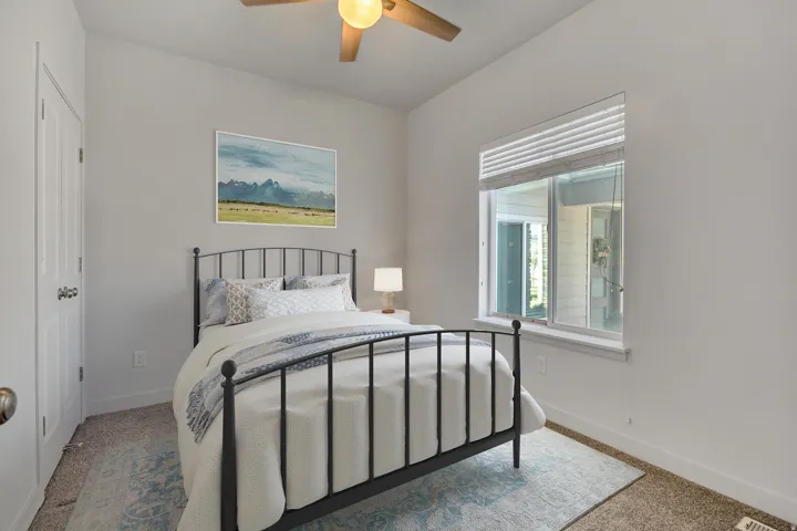Carpeted room featuring a ceiling fan, a window with blinds, and white interior doors