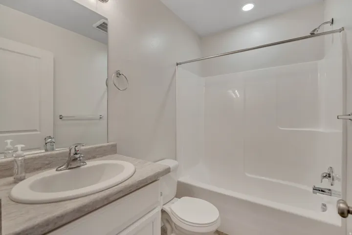Bathroom featuring a white vanity with an undermount sink, a light-toned countertop, and a chrome faucet