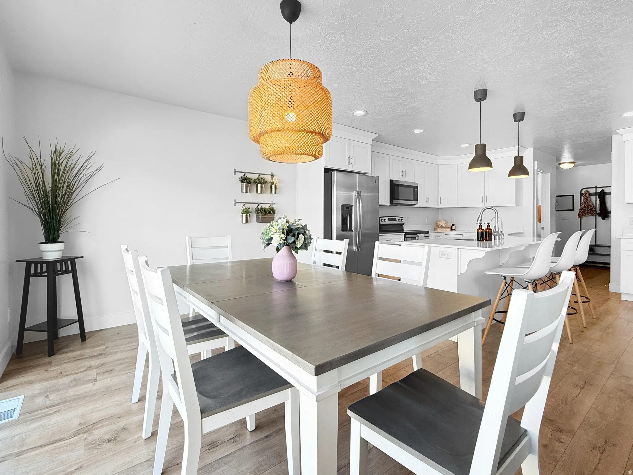 Open-concept dining area featuring wood-finish flooring and a decorative chandelier