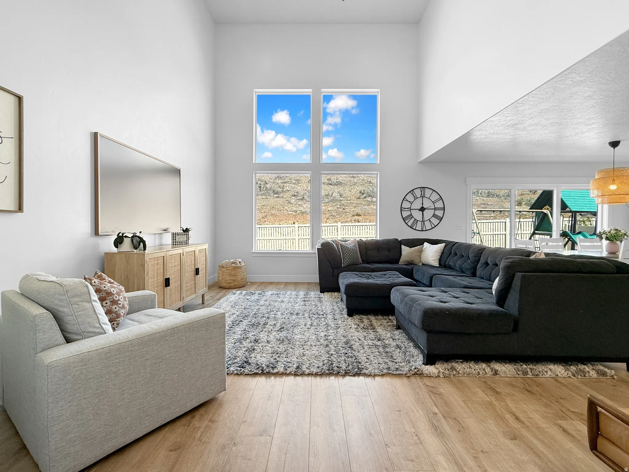 Open-concept living space featuring high ceilings and wood-finish flooring