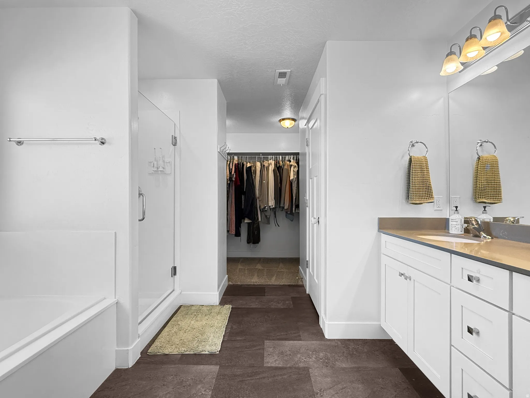 White cabinetry vanity with a light countertop, integrated sink, and an overhead four-light fixture